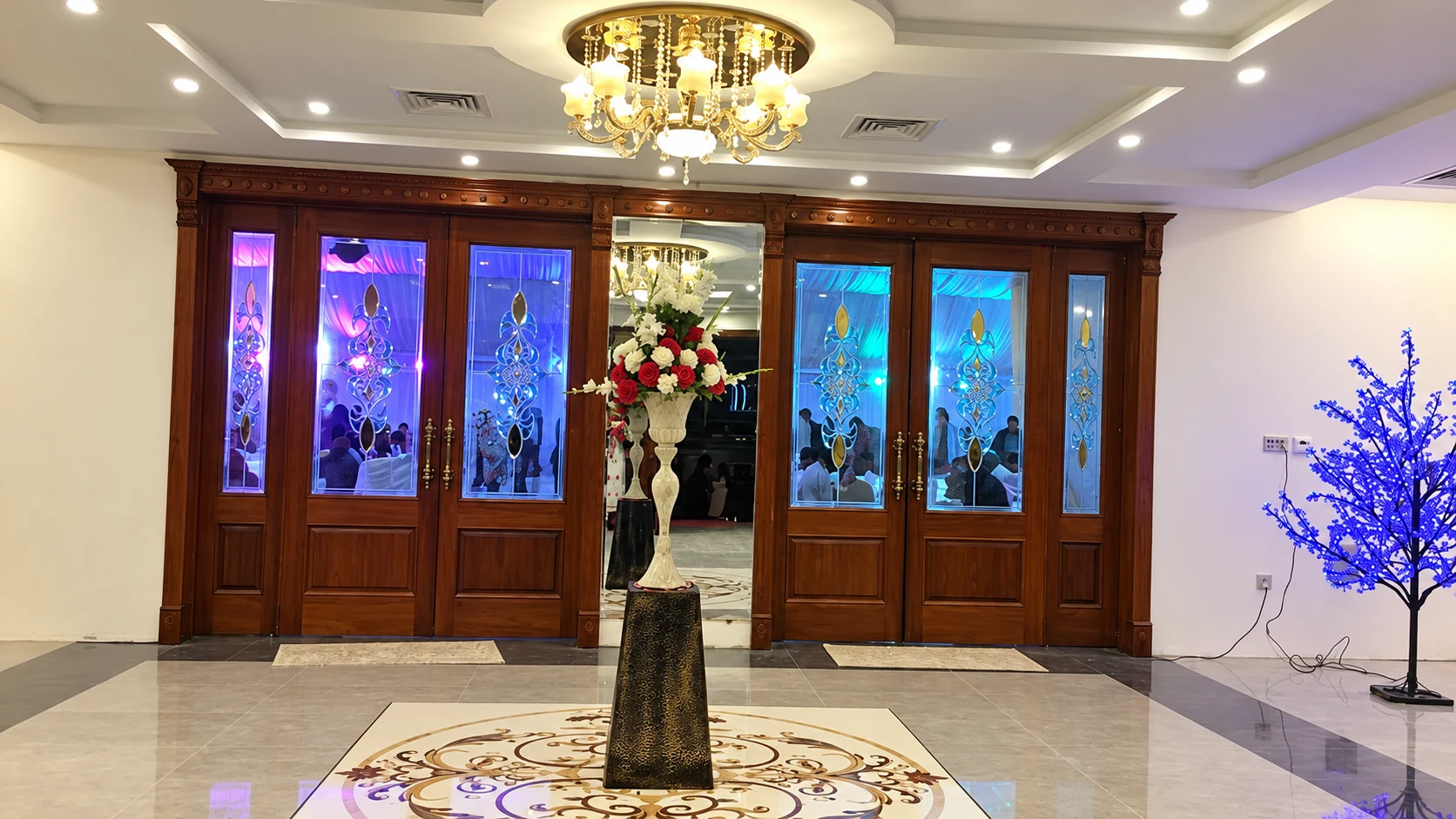 Carved wooden doors with stained glass at the hall entrance
