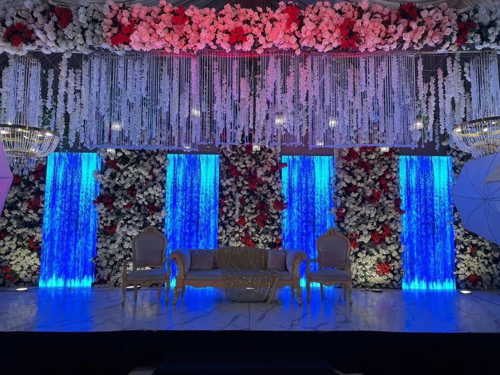 Stage with blue-lit water panels and floral columns